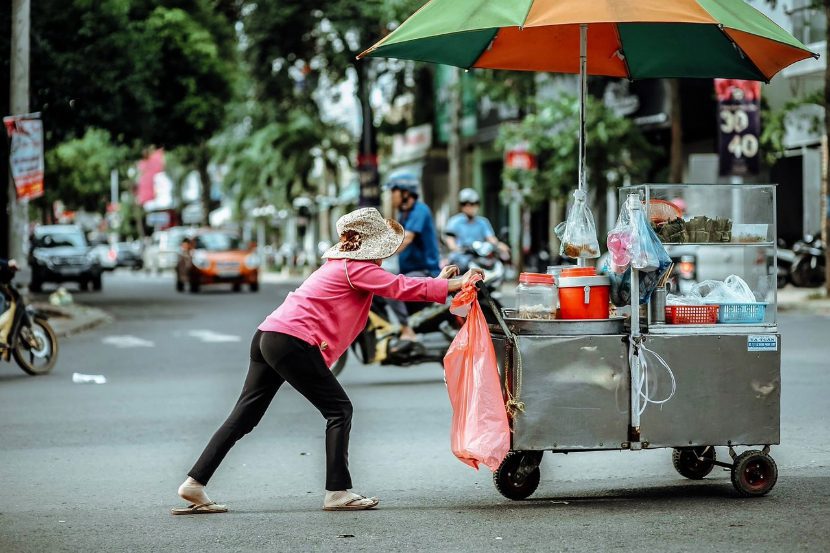 woman pushing food cart in Vietnam